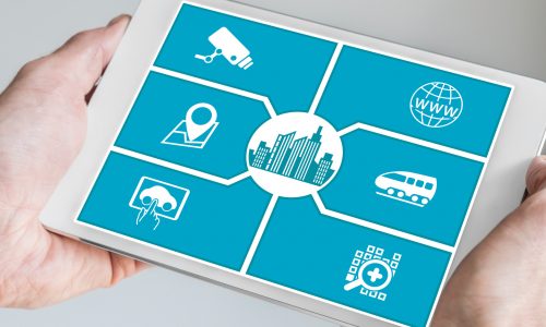 Smart city concept. Hand holding tablet or smart phone with icons of connected devices.